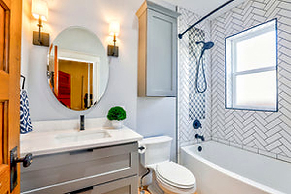 Bright white bathroom with walk-in shower and continuous floor tile