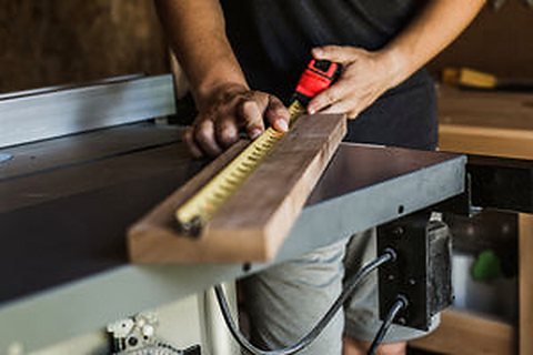 Carpenter measuring timber on site